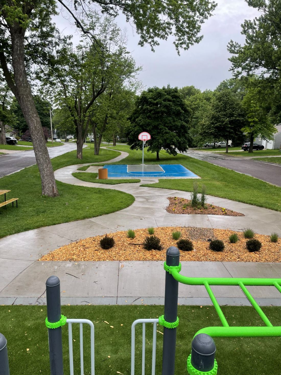 Robinson Park post-tension basketball court with striped blue surfacing and curved concrete pathways, built by Kansas Construction Services