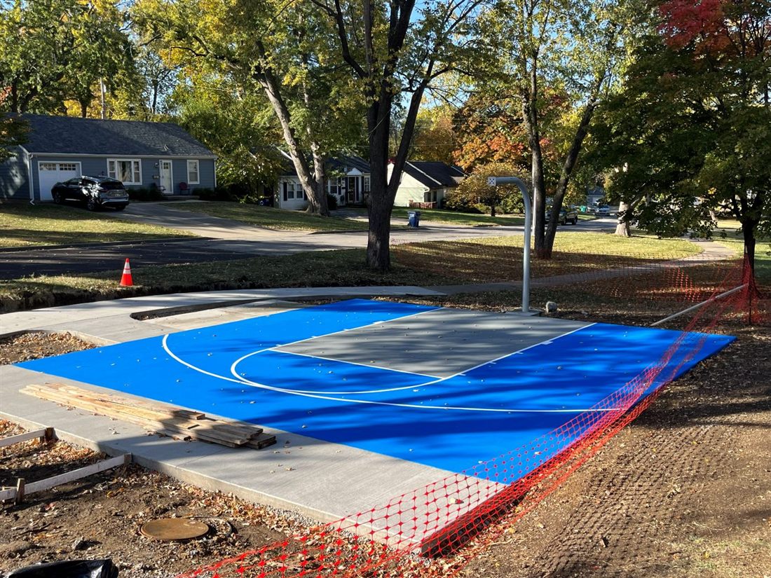 Post-tension concrete court at Robinson Park with blue acrylic surfacing and white line striping