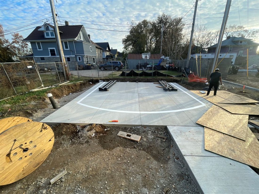 Court line striping being laid out on a new concrete slab at the Heroes Home Gate project